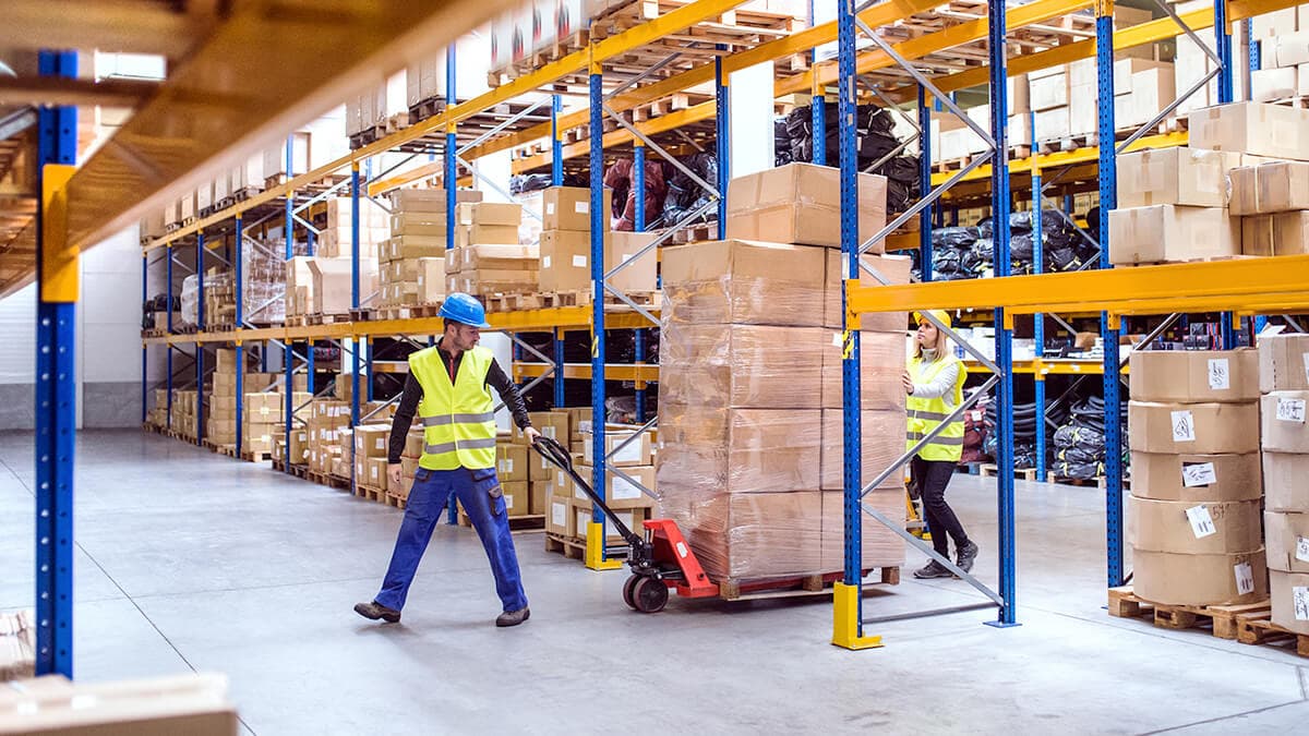 Warehouse crew loading palletized freight with a pallet jack